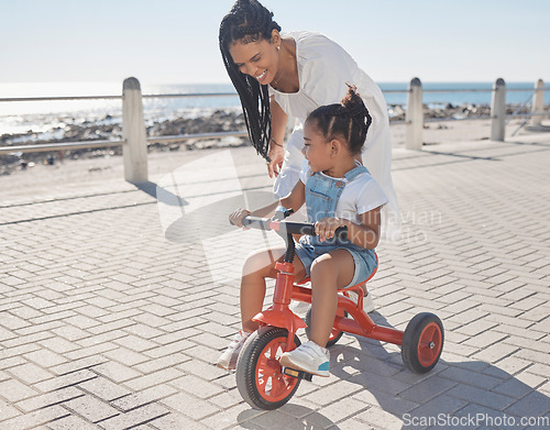 Image of Summer, ocean and mother with girl on bicycle enjoying holiday, vacation and quality time together on weekend. Family, love and mom with young child on bike for support, freedom and adventure by sea