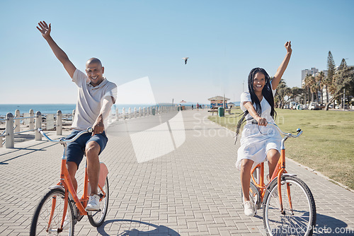 Image of Couple, bicycle and celebrate happiness for freedom on beach, travel holiday and summer vacation. Happy man, woman smile and cycling bike, cheerful and laughing together for love in ocean sidewalk