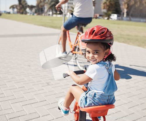 Image of Happy, portrait or child cycling on bike learning to ride outdoors for exercise or learning development. Safety, smile or excited young girl riding a bicycle on city sidewalk path in California, USA