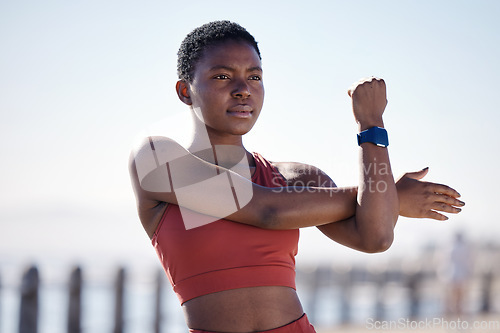 Image of Fitness, exercise and black woman stretching in city for healthy lifestyle, wellness and cardio workout. Sports, motivation and female athlete ready to start running, marathon training and jog by sea