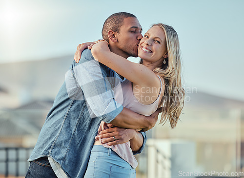 Image of Interracial couple, kiss and hug outdoor for romance, relationship and happiness together. Portrait, woman and man hugging with affection, support and trust in marriage, love and commitment in city