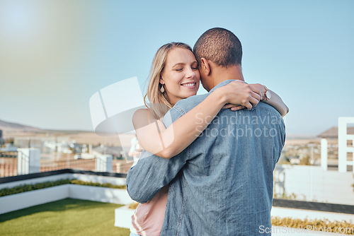 Image of Rooftop, love and couple hug in city enjoying summer holiday, weekend and vacation in Los Angeles. Romance, relationship and interracial man and woman embrace, bonding and hugging on urban adventure