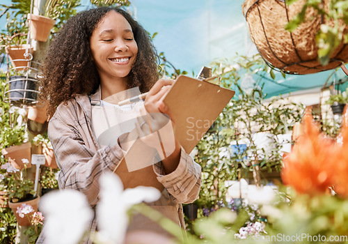 Image of Small business, plants and black woman with inventory, quality control and checklist clipboard in nursery. Smile of satisfied business owner writing quality assurance notes in flower garden.