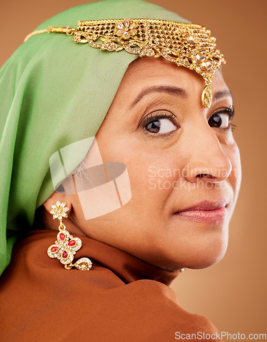 Image of Mature muslim woman, face or fashion hijab on studio background with traditional jewellery, religion jewelry or trendy accessory. Zoom, portrait or middle aged Islamic model in stylish hijab earrings