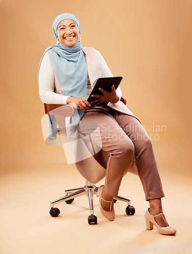 Image of Muslim, woman and tablet technology on studio background for website, internet search and online app in chair. Happy portrait, islamic hijab and mature lady, model and digital connection in Malaysia