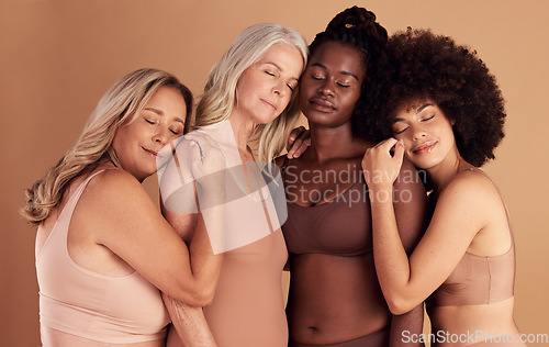 Image of Support, diversity and women with hug for body positive marketing, solidarity and advertising underwear on a studio background. Collaboration, affection and model friends hugging for empowerment