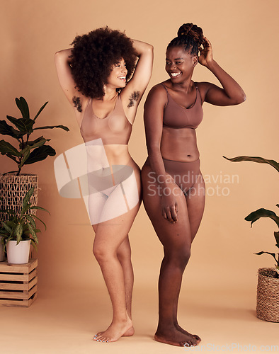 Image of Diversity, body and natural with black woman friends in studio on a beige background for beauty or equality. Health, wellness and armpit hair with a model female and friend posing in underwear