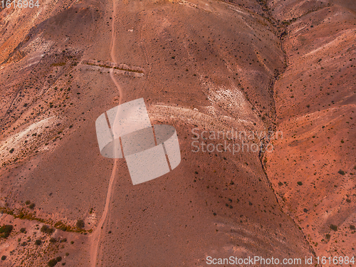 Image of Aerial shot of the textured yellow nad red mountains resembling the surface of Mars