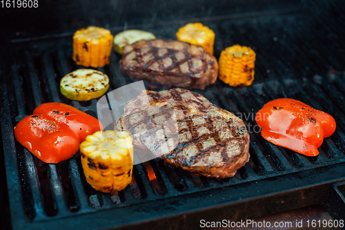 Image of Beef steaks on the grill with flames