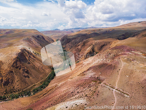 Image of Aerial shot of the textured yellow nad red mountains resembling the surface of Mars