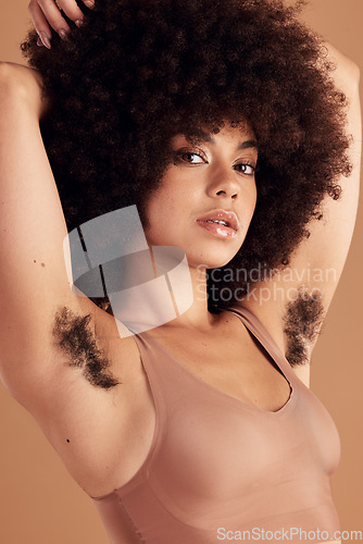 Image of Armpit hair, body positivity and portrait of a black woman in studio on a brown background for natural care. Health, wellness and empowerment with an attractive young afro female showing her underarm