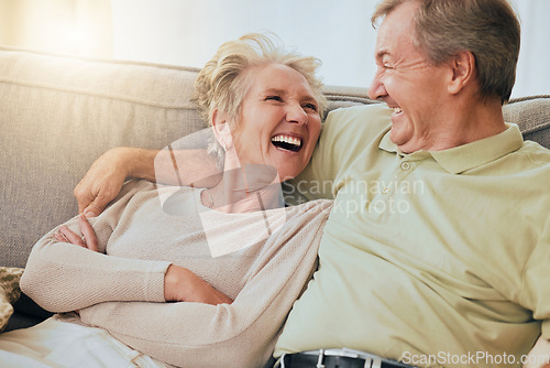 Image of Elderly couple, laugh and hug on sofa in happy relationship, silly face or bonding together at home. Senior couple laughing, humor or relaxing while making funny goofy faces on living room couch