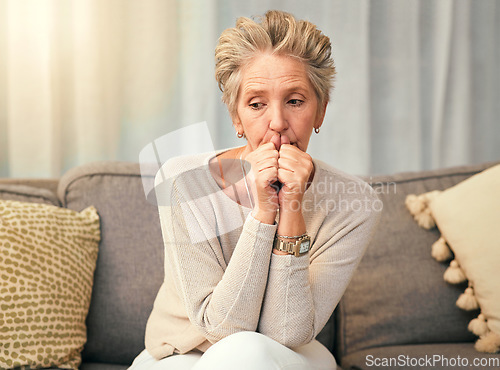 Image of Anxiety, depression and elderly woman on sofa thinking, worry and suffering memory loss in living room. Sad, confused and senior woman on couch afraid, phobia and suffer from alzheimers or dementia