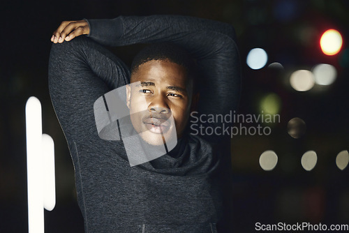 Image of Black man, runner and stretching in night city for fitness, health and exercise, wellness and mindset. Young athlete warm up, arms and workout, sports training and body performance in dark urban road