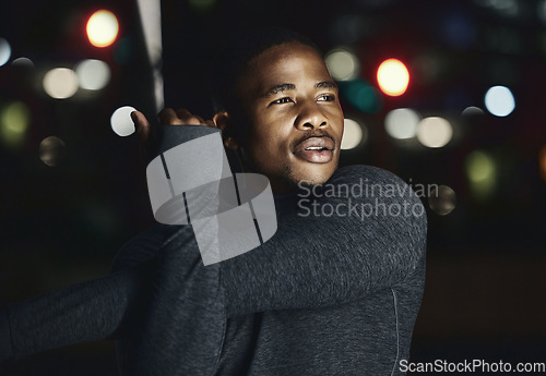 Image of Black man, fitness and stretching at night in the city for workout, exercise or preparation in the outdoors. African American male in evening warm up arm stretch getting ready for cardio exercising