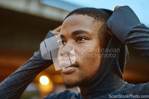 Image of Fitness, black man and hoodie in city running, exercise and workout for motivation, strong mindset and energy of healthy goals. Thinking, runner and sports athlete with focus to start cardio training