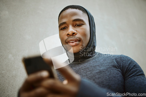 Image of Fitness, black man and phone typing in city to check social media, internet or search mobile app, online sports blog and exercise tech. Young athlete reading notification on smartphone before workout