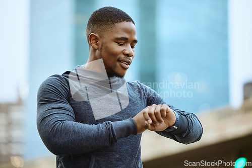 Image of Fitness, black man and checking time in the city ready for exercise, workout or cardio training in the outdoors. Active man in sports looking at smart watch for heart monitoring, rate or performance