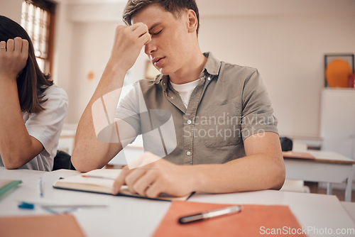 Image of Stress, headache and student in classroom with anxiety, mental health risk and burnout for study, education and learning problem. Tired, fatigue and depression of teenager in school or college desk