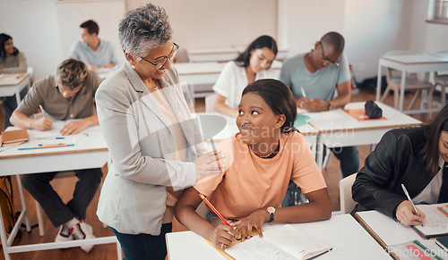 Image of Teacher, student and classroom for test, knowledge and learning for higher education. Young female, black woman or educator helping pupil in exams, talking or students writing notes in books or focus