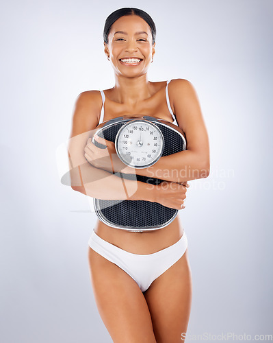 Image of Portrait, black woman and scale for diet, weight loss and smile for healthy lifestyle, wellness and relax on grey studio background. African American female, weigh and health for body care or balance