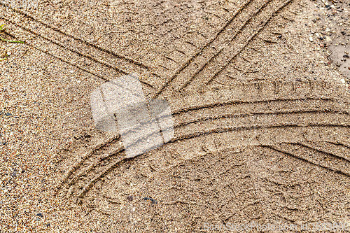 Image of car tire tracks on a sandy road