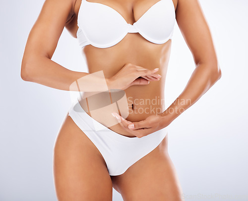 Image of Woman, body and hands frame stomach for skincare beauty, fitness wellness or model liposuction in studio. Cosmetic tummy tuck, dermatology care and digestion or gut balance with person in underwear