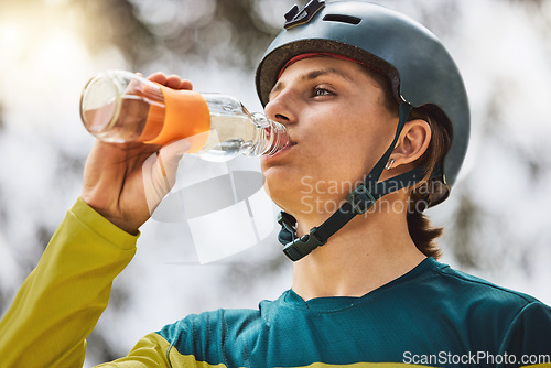 Image of Cycling, man and drinking water for exercise, bike training or workout recovery after mountain biking marathon in forest. Healthy athlete, hydrate and fitness for health and bicycle adventure outdoor