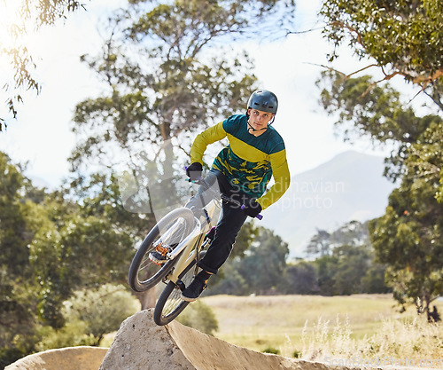 Image of Mountain bike man, air ramp and outdoor with helmet, extreme sport and focus for fitness, speed and training. Bmx bicycle. sports expert and fast jump in nature, trail and cycling for competition
