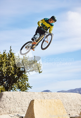 Image of Man, cyclist and mountain biking in free style, tricks or extreme hill jumping in the nature outdoors. Professional male cycling in the mountain with bicycle in the air for freedom, parkour or sports