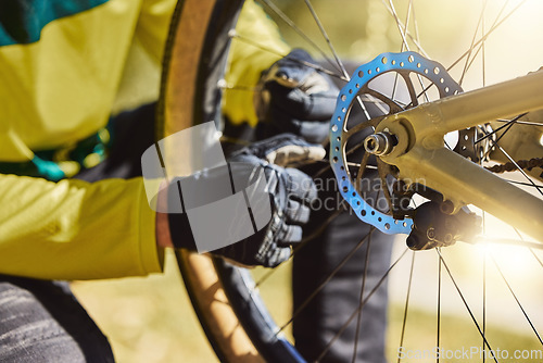 Image of Hands of man on bicycle wheel while outdoor for cycling with mountain bike to fix puncture, tire maintenance and repair in nature. Athlete doing inspection before training, adventure and travel