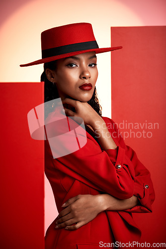 Image of Fashion, studio and stylish woman in a suit with a seductive, sensual and elegant outfit. Edgy, fashionable and portrait of female African model with trendy style posing by orange and red background.