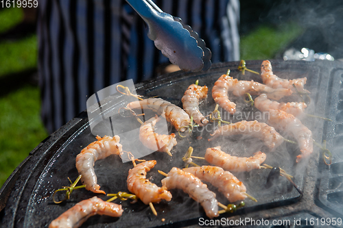 Image of A professional cook prepares shrimps