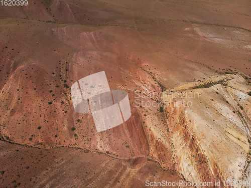 Image of Aerial shot of the textured yellow nad red mountains resembling the surface of Mars