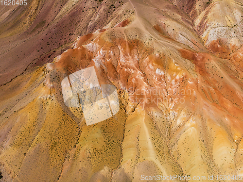 Image of Aerial shot of the textured yellow nad red mountains resembling the surface of Mars