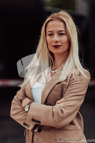 Image of A powerful portrait of a businesswoman, standing confidently with her arms crossed, representing the determination of the female gender and embodying strength and success