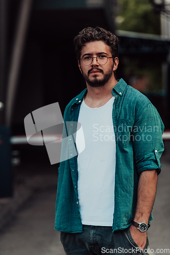 Image of A portrait of a modern man, exuding confidence and style, against an outdoor backdrop, showcasing his charisma and fashionable demeanor.