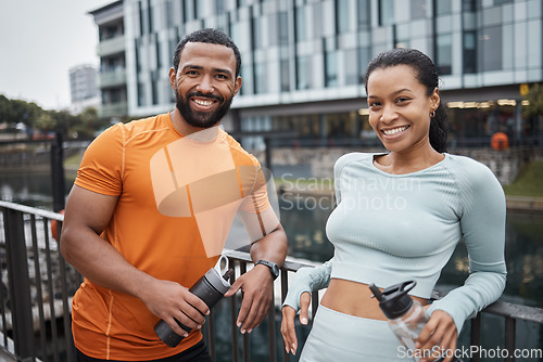 Image of Black couple, portrait and fitness in urban city, workout partner with water bottle for hydration and relax after exercise. Happy black man with black woman and wellness, active lifestyle in Chicago.