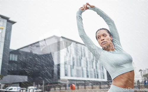 Image of Black woman, stretching and fitness in rain and city for running training for a marathon. Workout, exercise and run goal motivation of a woman athlete and runner doing sports in winter health warm up