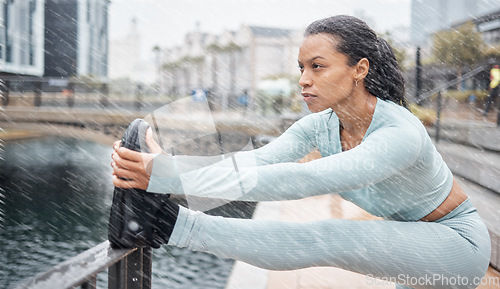 Image of Fitness, rain and woman stretching outdoor for muscle wellness, health and energy in winter with workout, running or training. City, Amsterdam and sports runner with legs exercise, cardio and workout