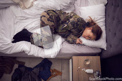 Image of Depression, anxiety and woman soldier in bed with ptsd, trauma and pills for suicide, phobia and mental health. Stress, thinking and army girl suffer with insomnia, drug addiction and fear in bedroom