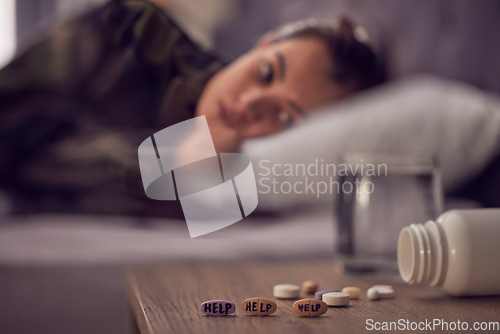 Image of Depression, anxiety and medicine with a suicide woman lying on her bed in the bedroom of her home alone. Mental health, help and pills with a female suffering from a psychology disorder in her home