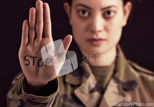 Image of Stop, war and hand of a military woman angry, frustrated and with sign against a dark black studio background. Army, anger and portrait of a soldier with body language and message to end a battle