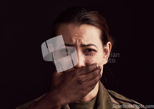 Image of Abuse, fear and hand over the mouth of a woman in studio on a dark background to stop gender violence. Portrait, mouth and silence with a female victim or hostage as a symbol of domestic violence