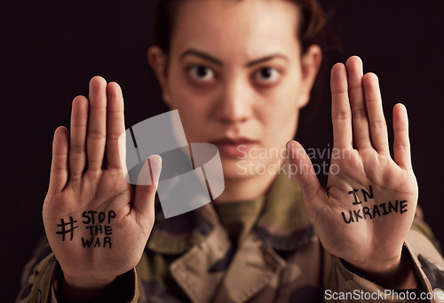 Image of Ukraine, war and stop with woman soldier showing her hands or palms in protect to military conflict. Army, freedom and politics with a female trooper in support of Ukrainian freedm or rights