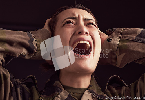 Image of PTSD, crying and trauma with a woman soldier shouting or screaming in studio on a dark background. Scream, grief and tears with a young army female suffering from military memories of war or pain