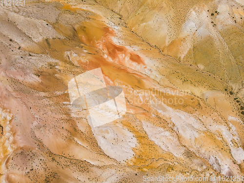 Image of Aerial shot of the textured yellow nad red mountains resembling the surface of Mars