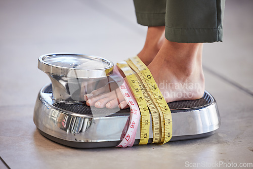 Image of Diet, weight loss and feet of a woman on a scale for body check, measure and balance to lose weight on the floor. Obesity, scales and girl with tape measure for obsession with health and body image