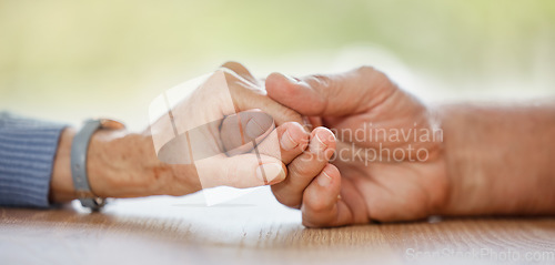 Image of Elderly couple, holding hands and support for comfort, love or help on table for compassion, pain or sympathy. Senior man, old woman and helping hand with empathy, trust and care in home for bonding