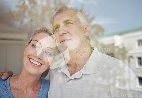 Image of Hug, thinking and senior couple at a window with vision of future, retirement peace and relax in their home. Idea, love and elderly man and woman with affection in their apartment looking from glass